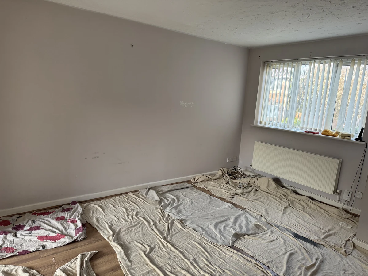 Bedroom with grey feature wall and radiator in Loughor by Daffodil Decor painters