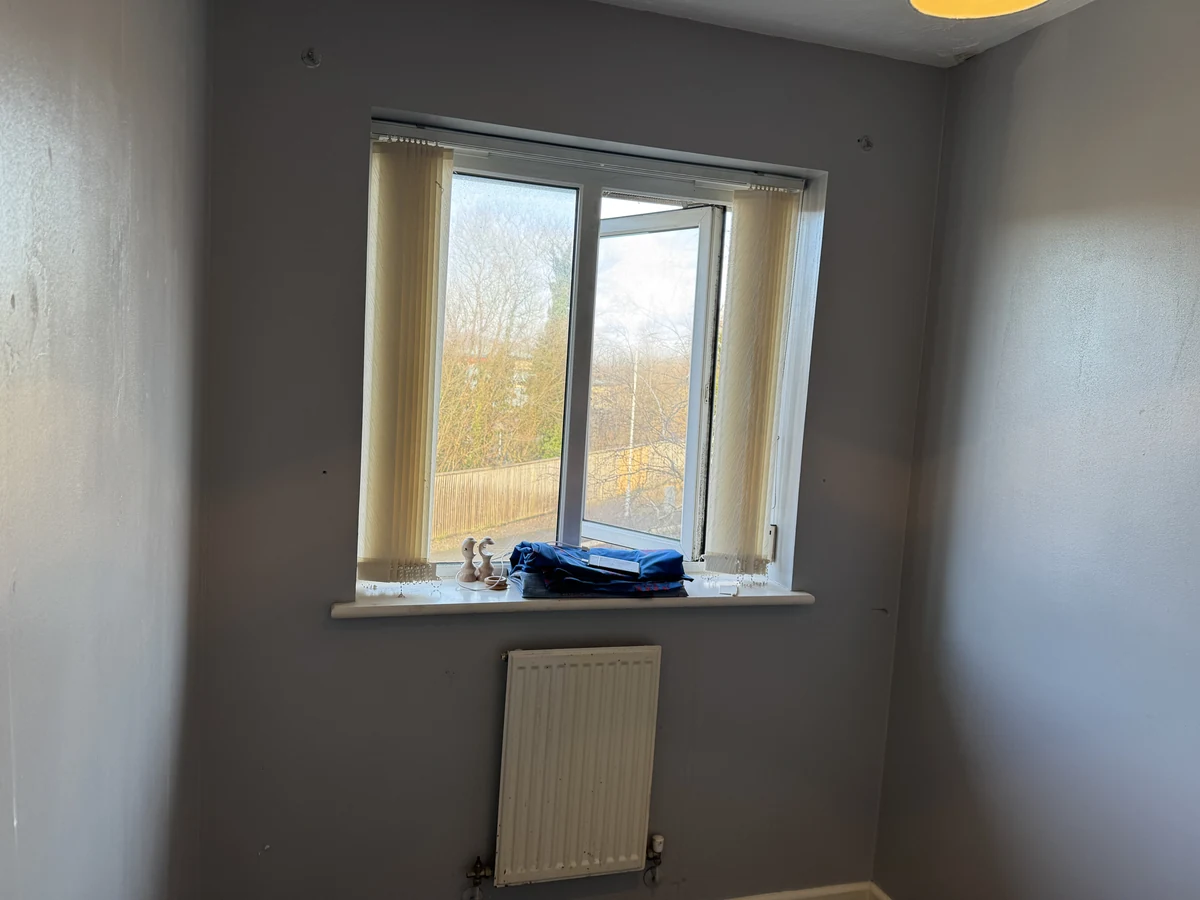 Bedroom freshly decorated in warm grey with natural window light, Neath refurbishment by Daffodil Decor