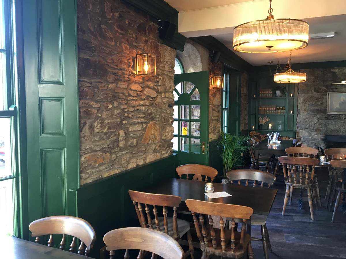commercial-interior-pub-wooden-panelling-wallpaper-swansea-daffodil-decor-4 Restaurant area with a stone feature wall, green panelling and wooden chairs