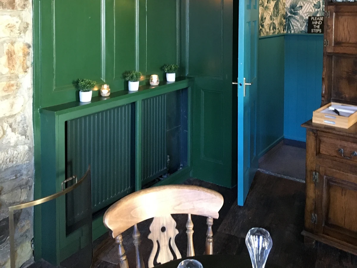 commercial-interior-pub-wooden-panelling-wallpaper-swansea-daffodil-decor-8 Green painted panelling and radiator cover beside a dining chair