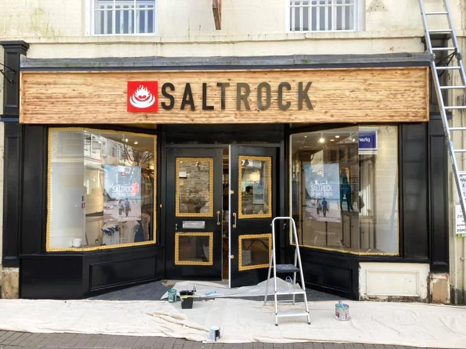 Painted shopfront with a stepladder and dust sheets on the pavement