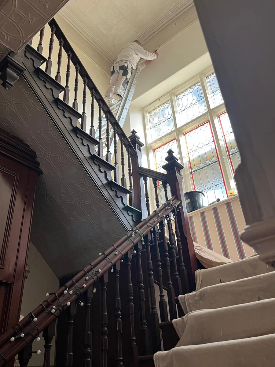 decorator-painting-stairwell-swansea-daffodil-decor Working at height over the staircase — ladder access, no scaffold, Swansea