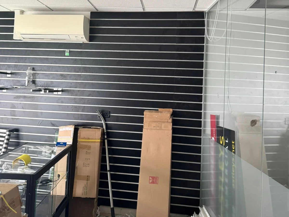 Black slatwall display wall at the Wimozee Technology shop in Swansea, by Daffodil Decor