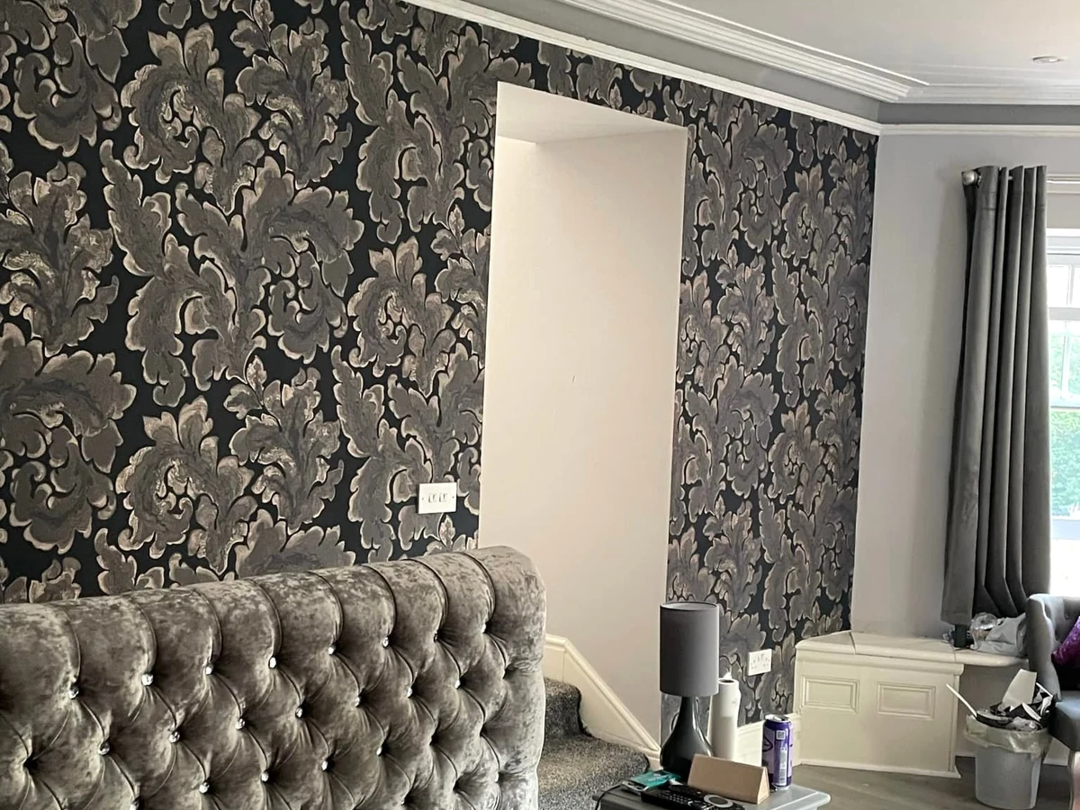 Wallpapered feature wall with dark floral pattern in a Birchgrove bedroom by Daffodil Decor
