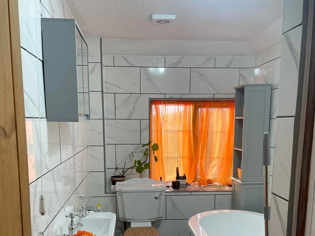 Wallpapering geometric pattern feature wall in bedroom by Daffodil Decor painters and decorators in Clydach